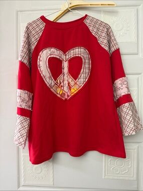 NWOT cute top with peace sign on the front, size large.